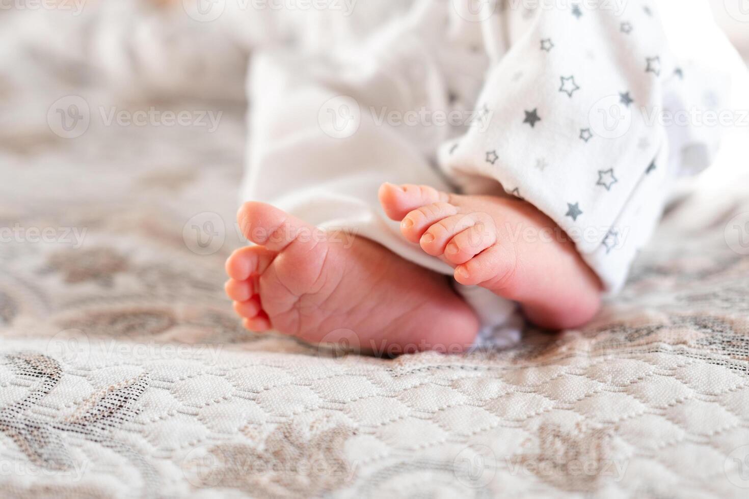 Newborn baby on a white blanket - tiny baby feet closeup photo