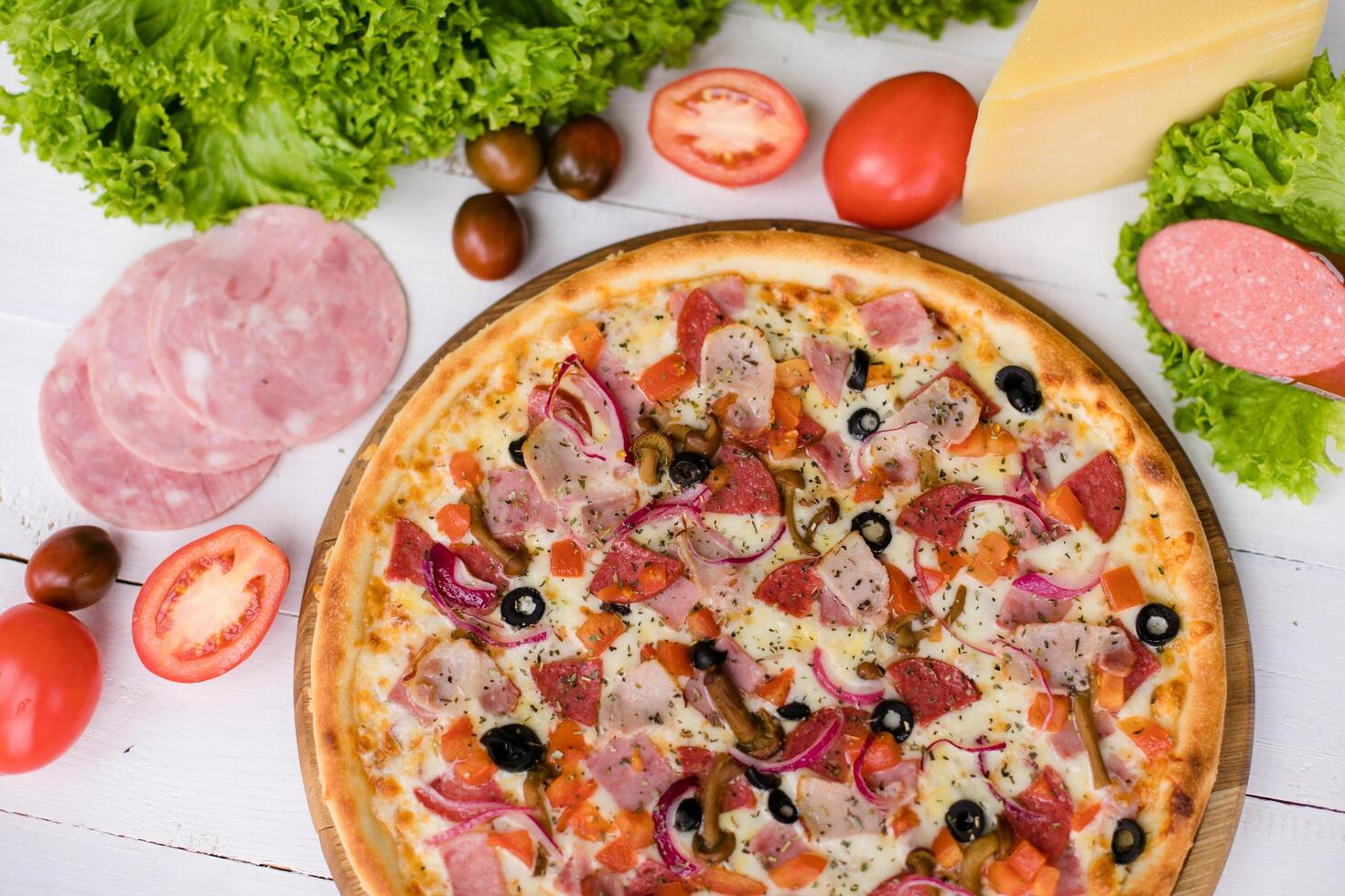 Delicious fresh Pizza with tomatoes, mashrooms, bacon and cheese mozzarella on the white wooden table. Top view. photo