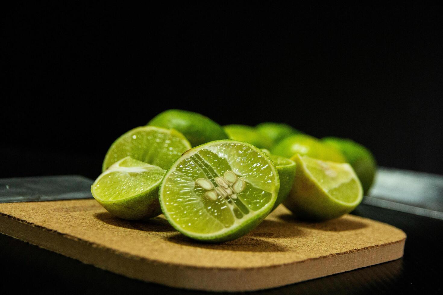 half of lime with seeds on wooden board photo