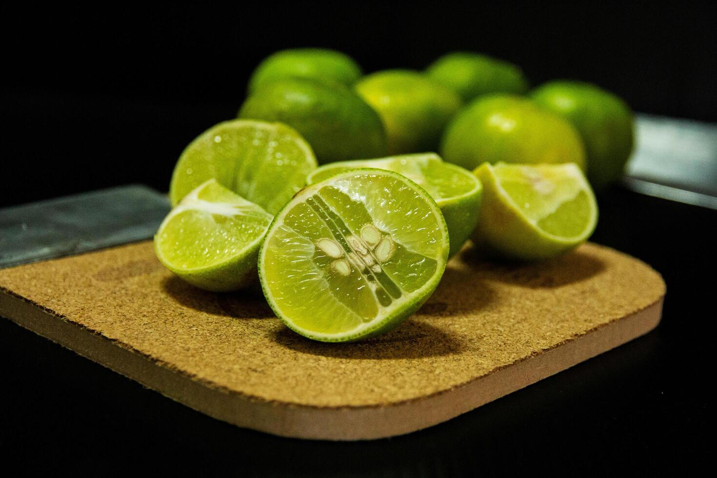 Cutted green lime on wooden board photo