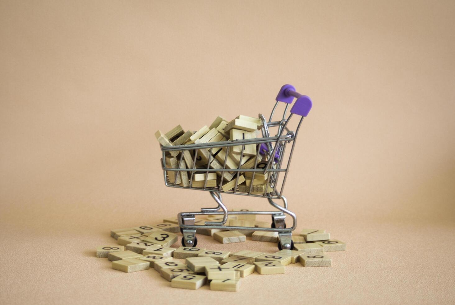Shopping cart and numberic wood block put on background. photo