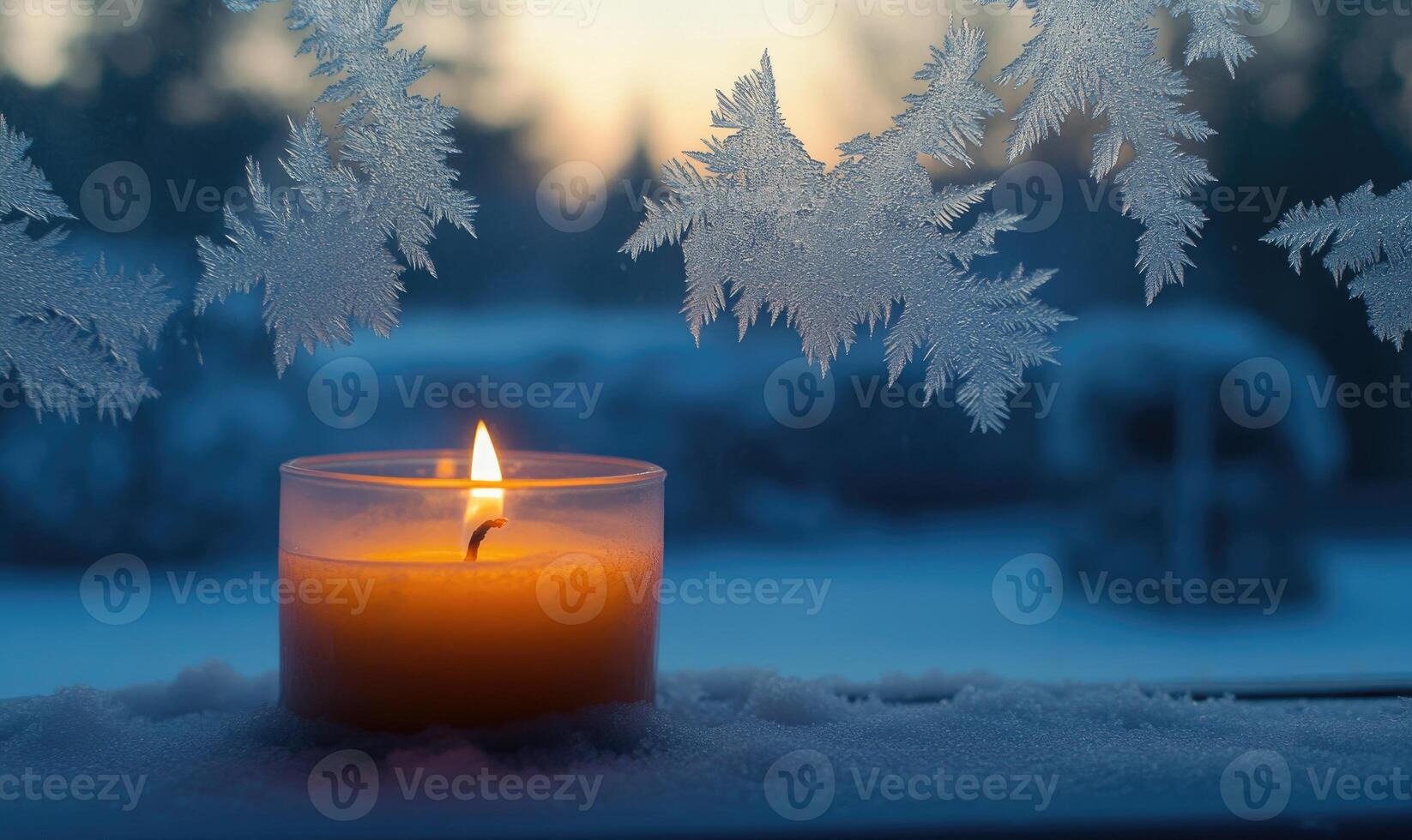 A candle is lit in a glass jar on a snowy window sill photo