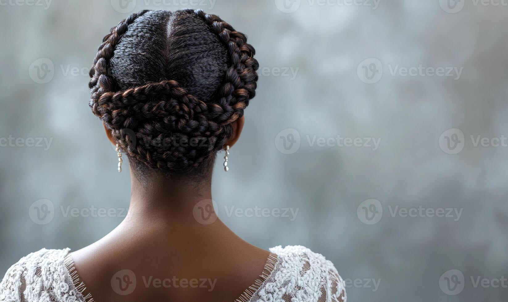 A woman with a braided hairstyle and earrings photo