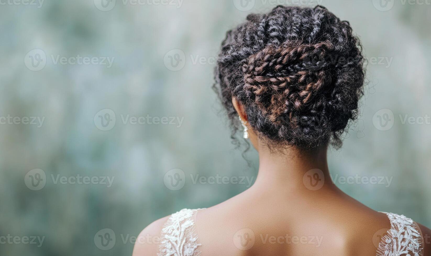 A woman with a braided hairstyle is wearing a white dress photo