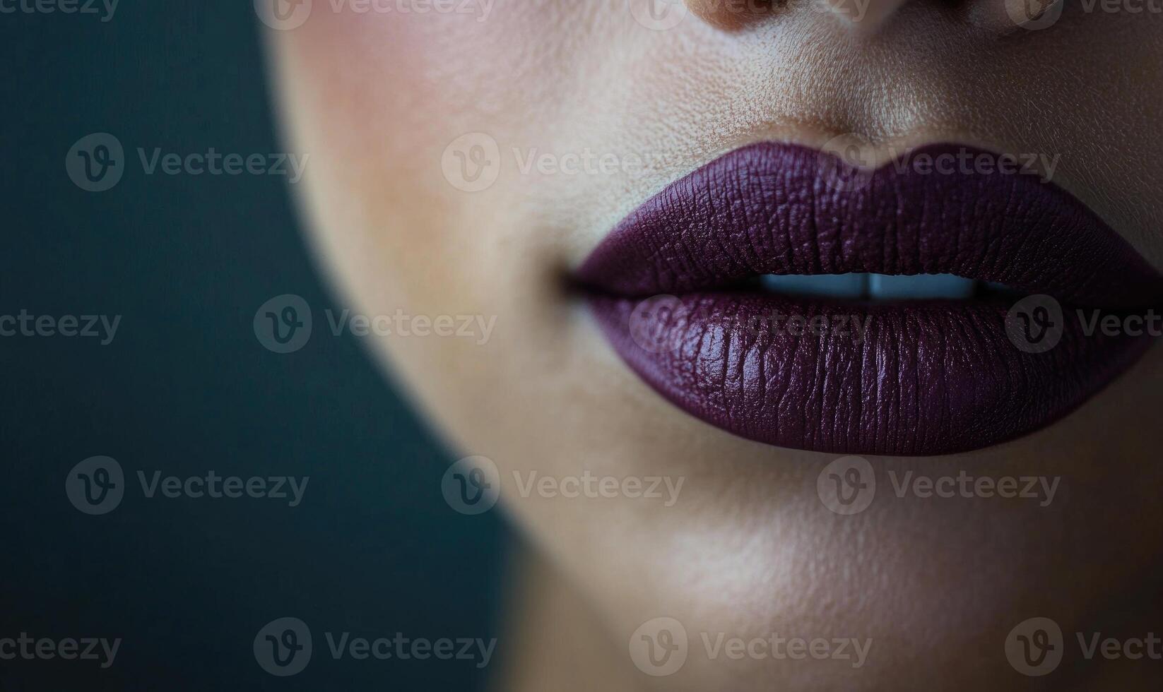 A woman's lips are painted with a deep purple lipstick photo