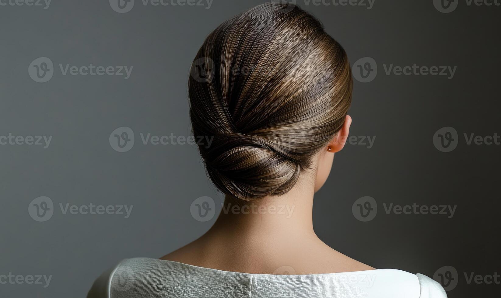 A woman with a bun hairstyle is wearing a white dress photo