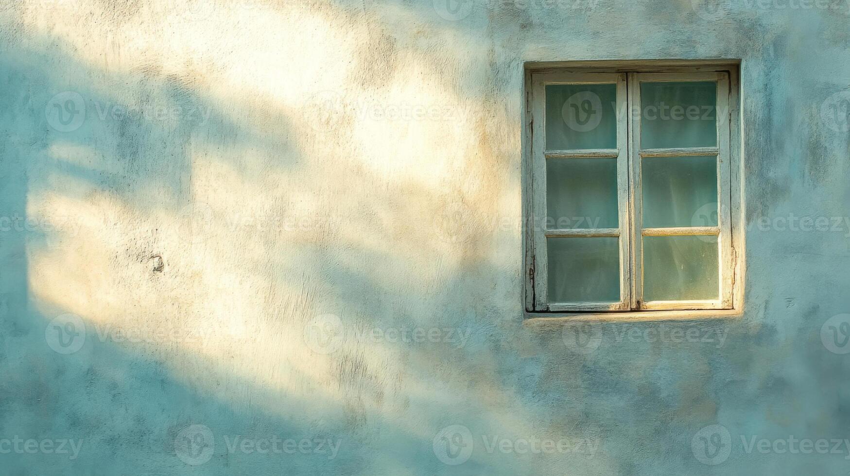 A Single Window on a Weathered Wall with Light Streaming Through photo