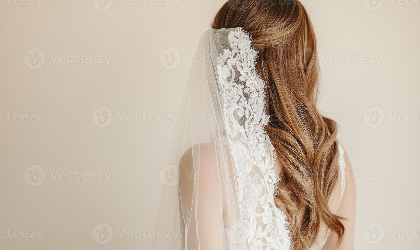 A woman with long blonde hair is wearing a white lace veil photo
