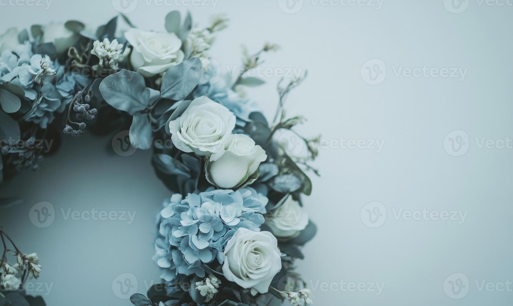 A wreath of flowers with blue and white flowers and a white rose photo