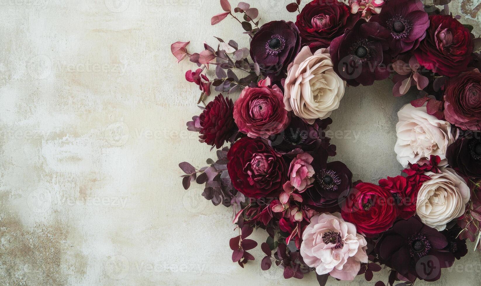 A wreath of red and pink flowers sits on a white background photo