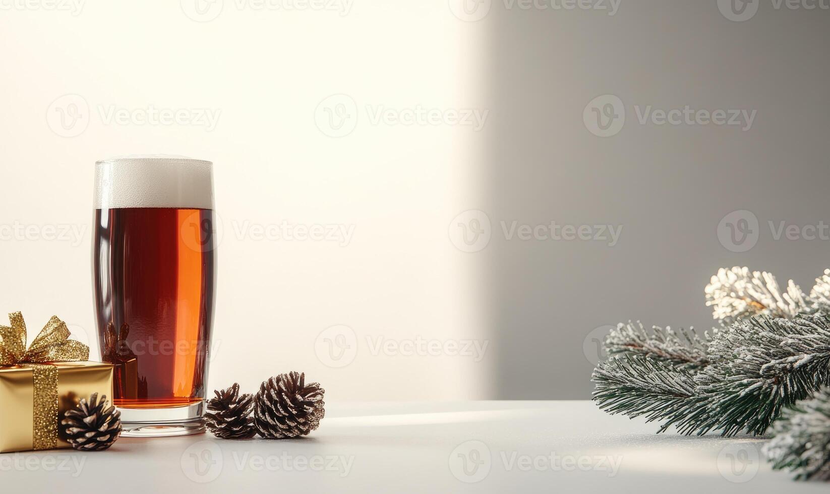 A glass of beer sits on a table next to a pine cone and a gold gift box photo