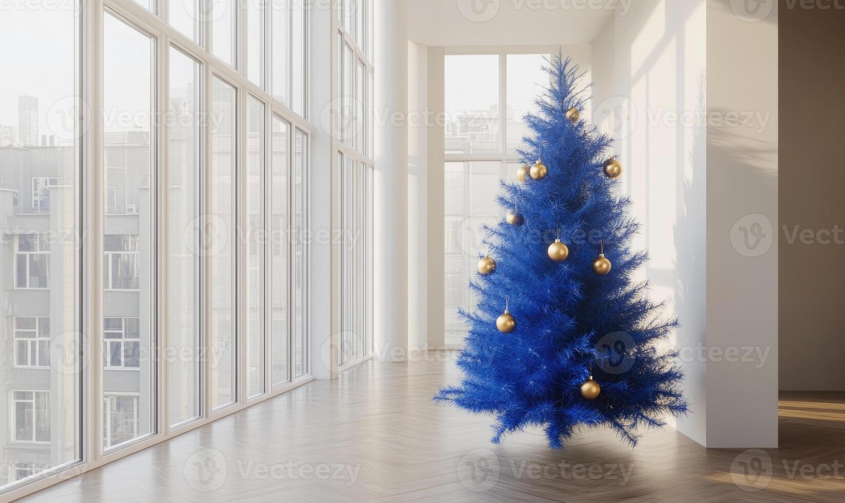 A blue Christmas tree with gold ornaments sits in a room with large windows photo