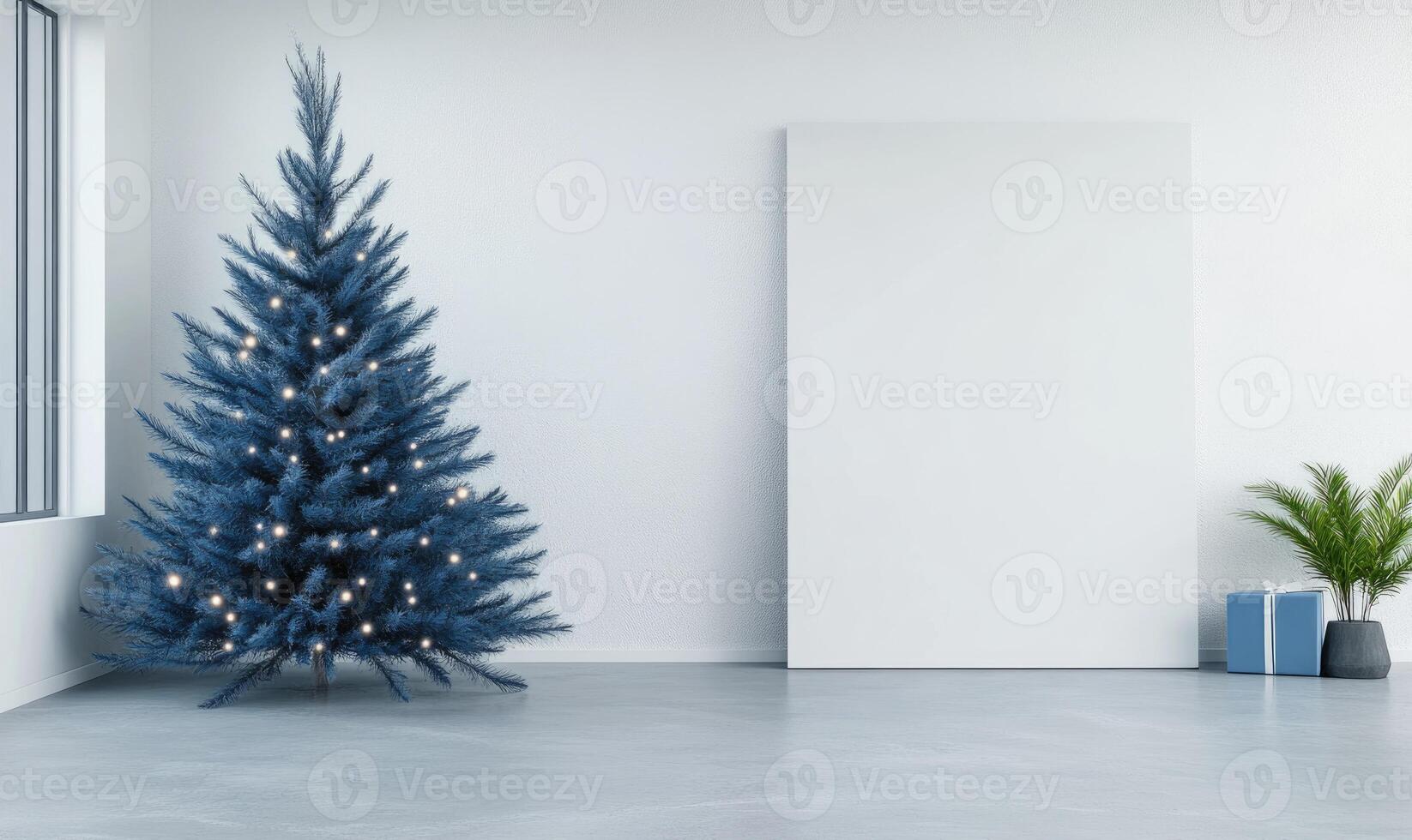 A blue Christmas tree sits in front of a white wall photo