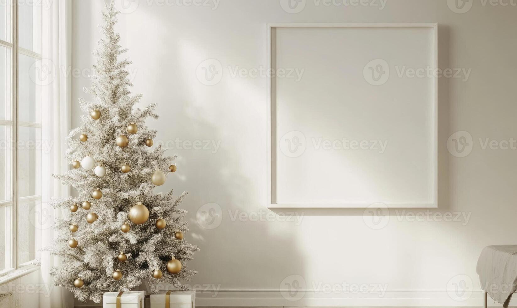 A white Christmas tree with gold ornaments sits in front of a white wall photo