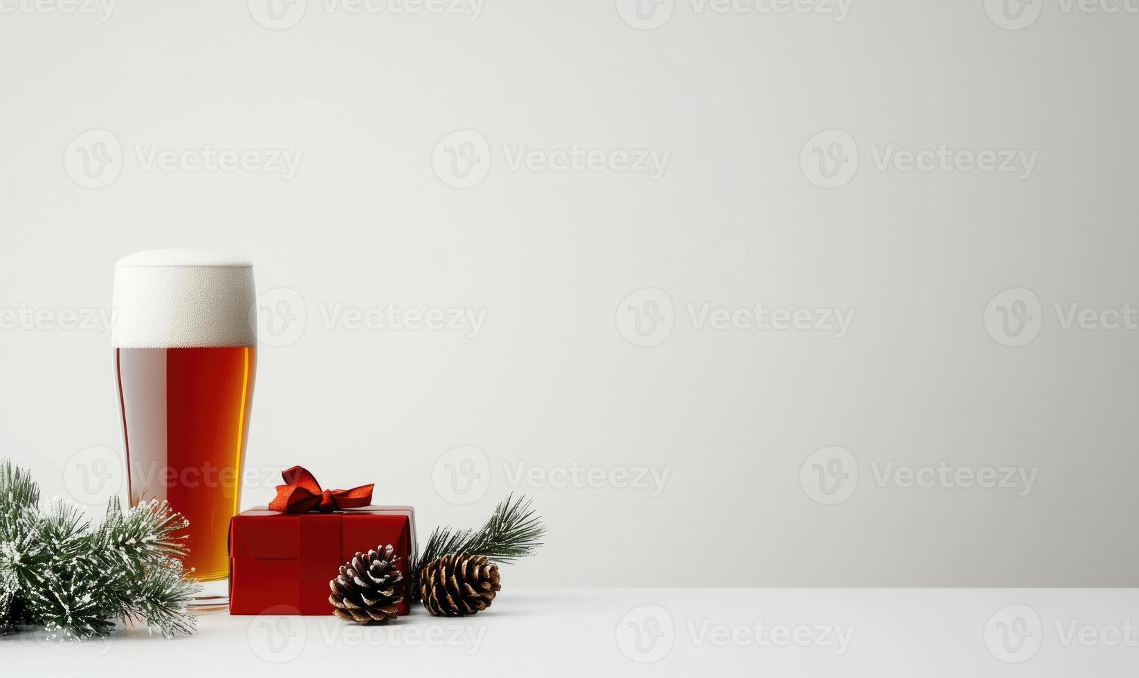 A glass of beer sits next to a red box with a ribbon on it photo