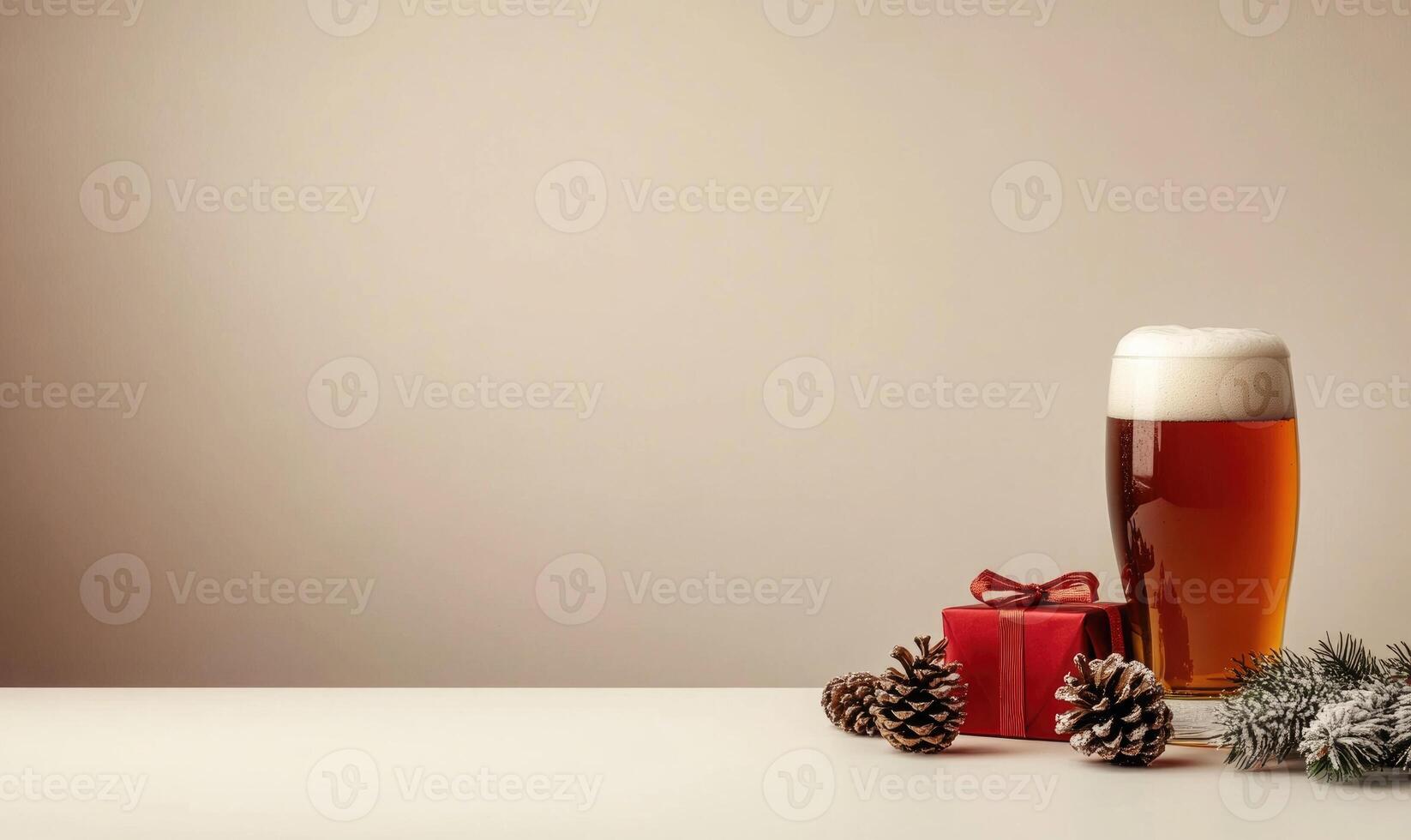 A glass of beer sits on a table next to a red box and pine cones photo