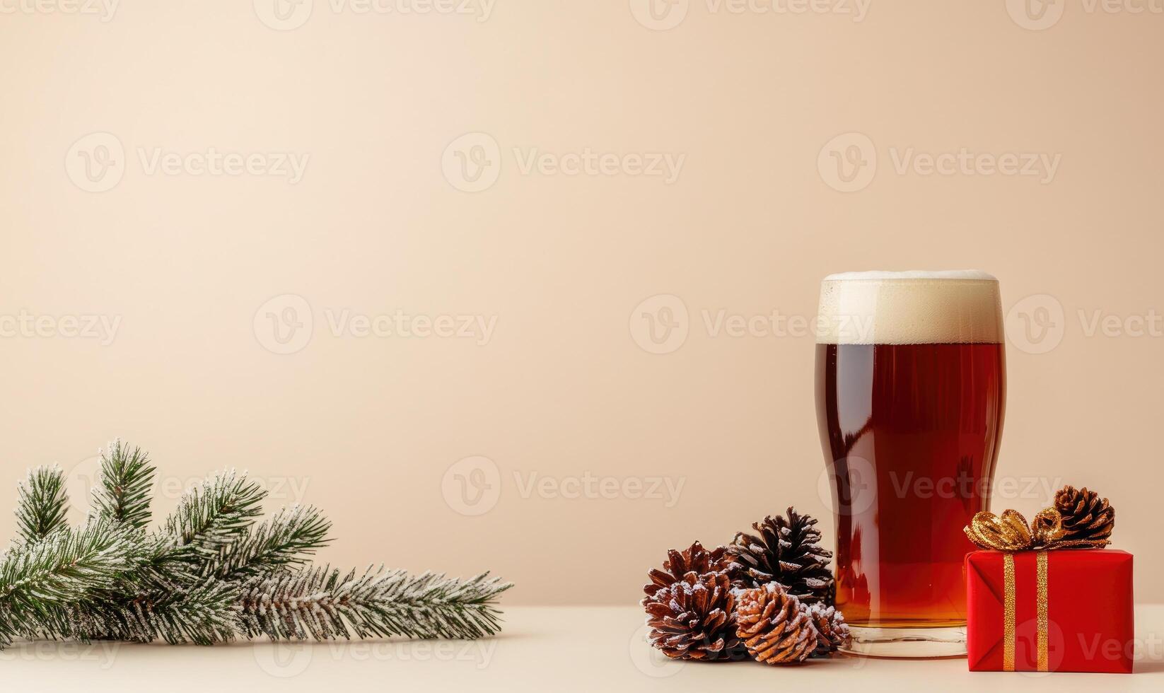 A glass of beer sits on a table next to a pine tree and a red box photo