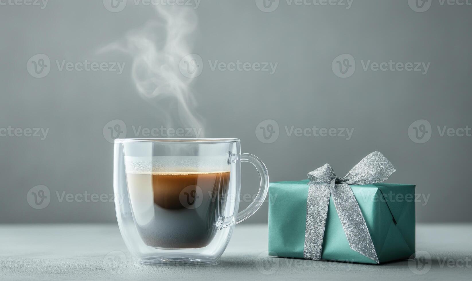 A cup of coffee with steam rising from it sits next to a gift box photo