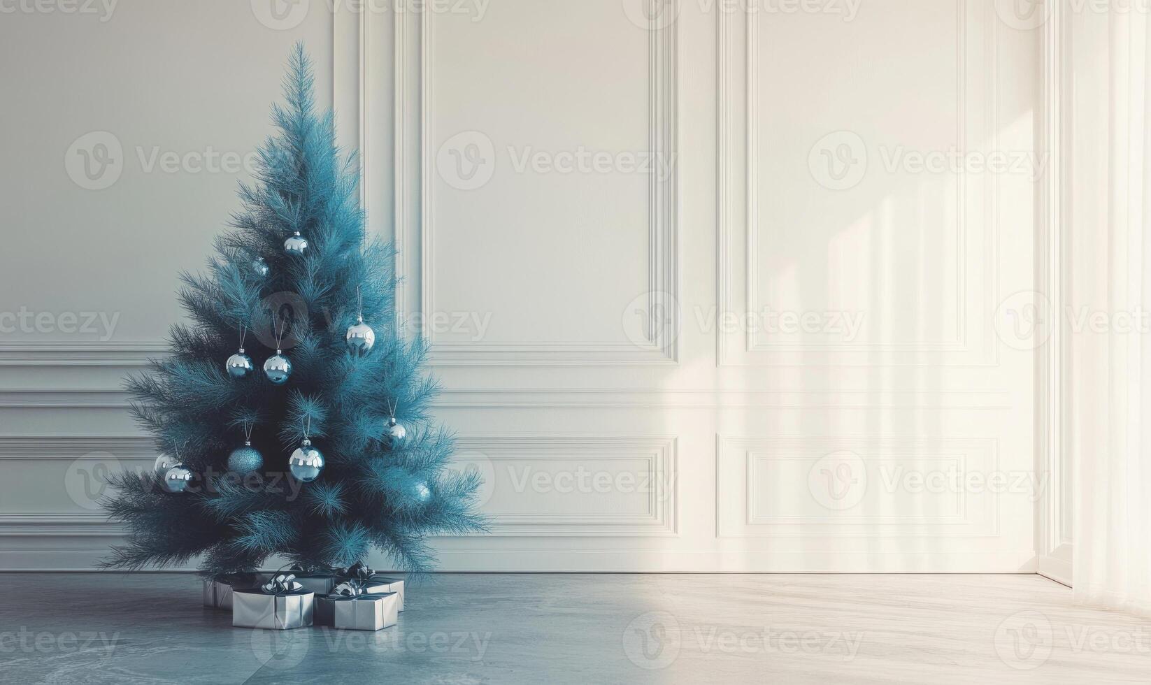 A blue Christmas tree with silver ornaments sits in a room with white walls photo