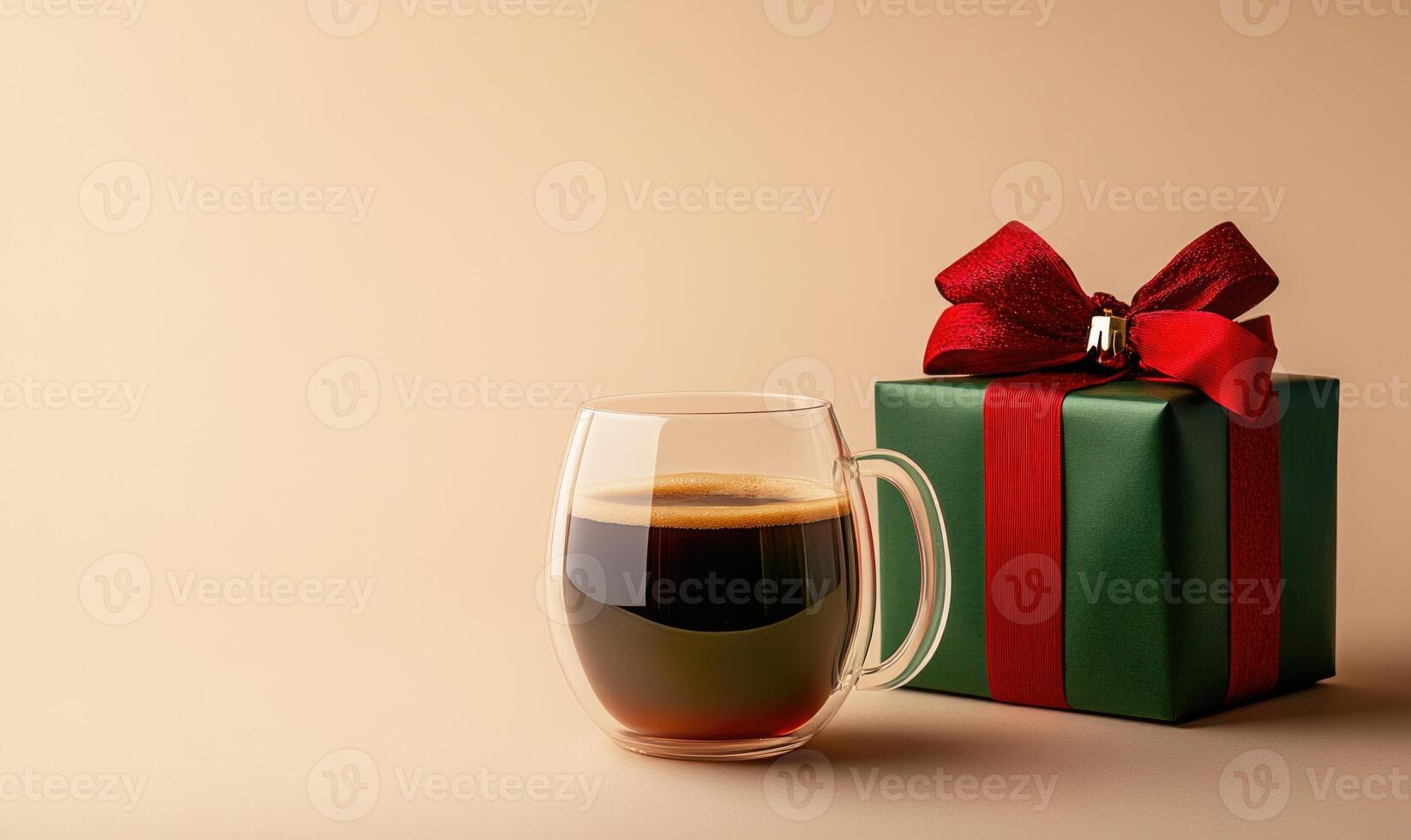 A cup of coffee sits next to a green box with a red ribbon photo