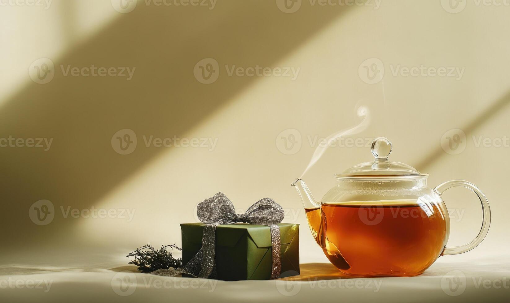 A green box with a bow sits next to a teapot photo