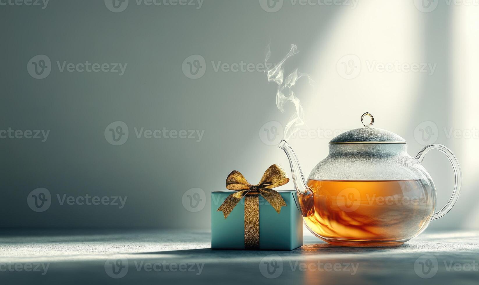 A tea kettle sits on a table next to a blue box with a gold bow photo