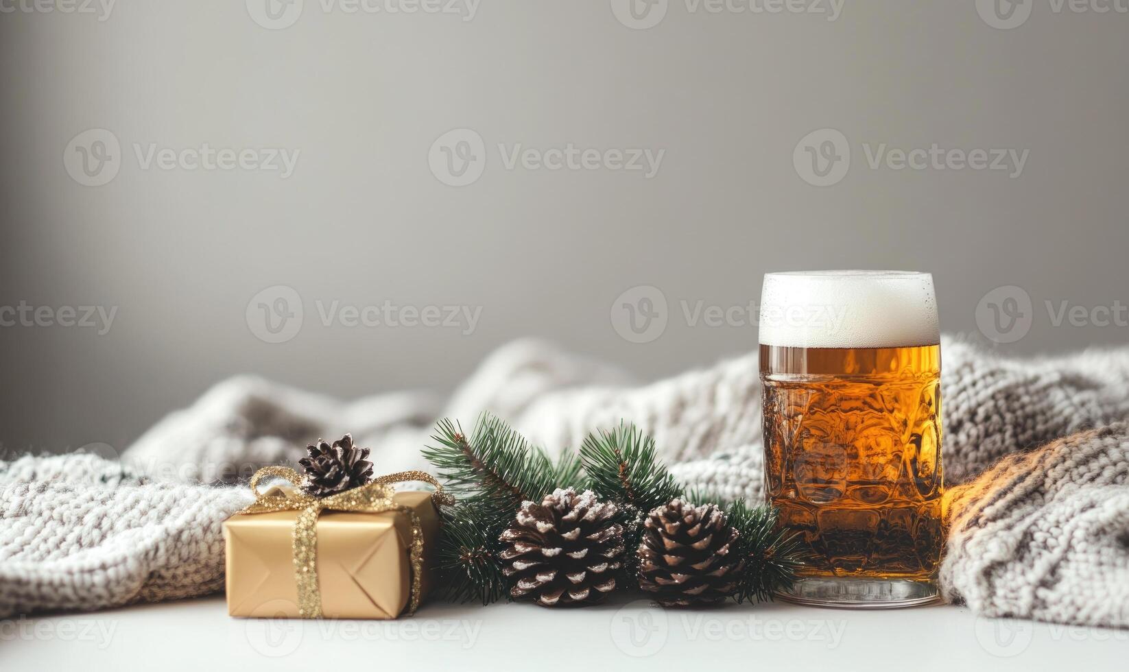 A glass of beer sits on a table next to a box with a ribbon on it photo