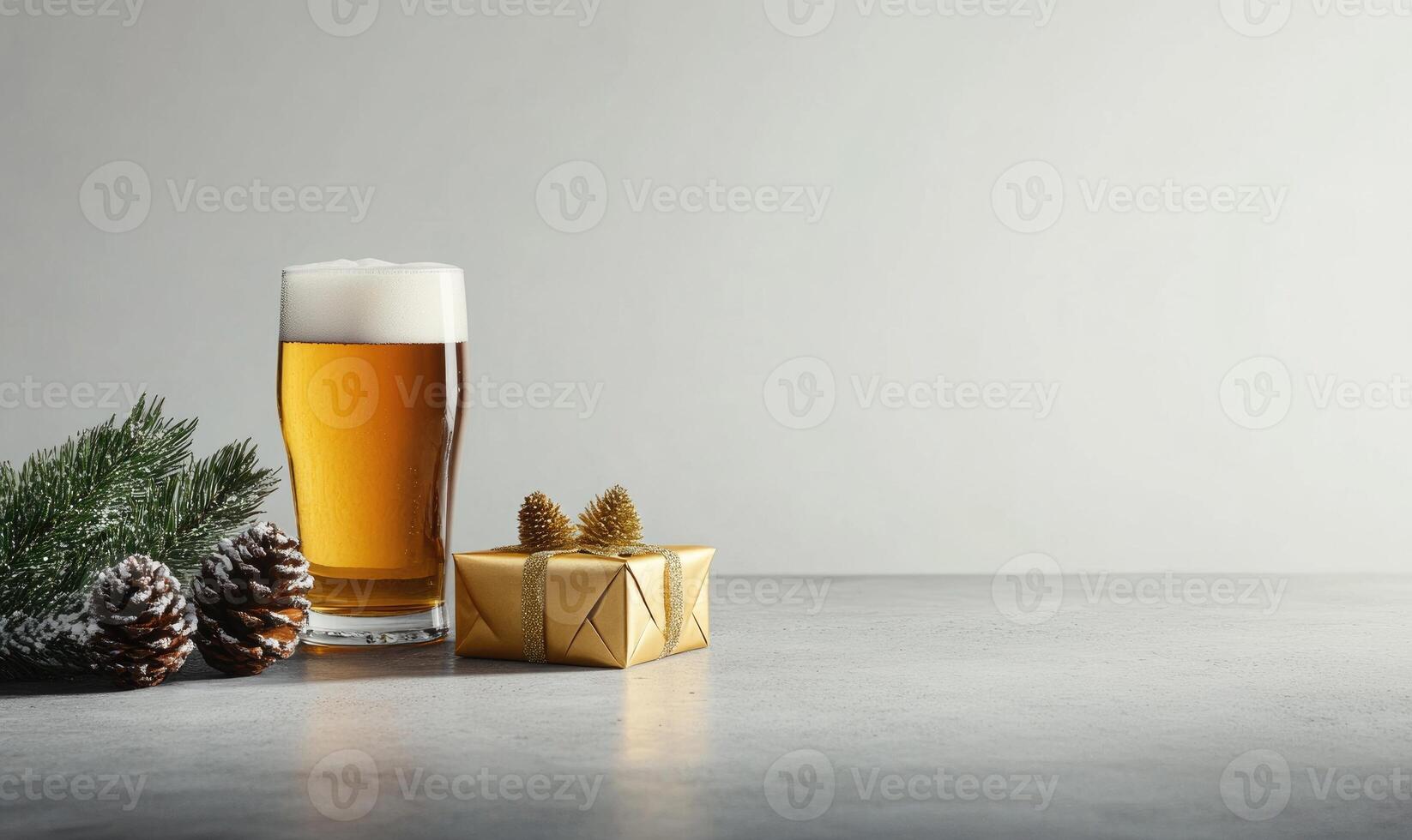 A glass of beer sits on a table next to a gold wrapped gift box photo
