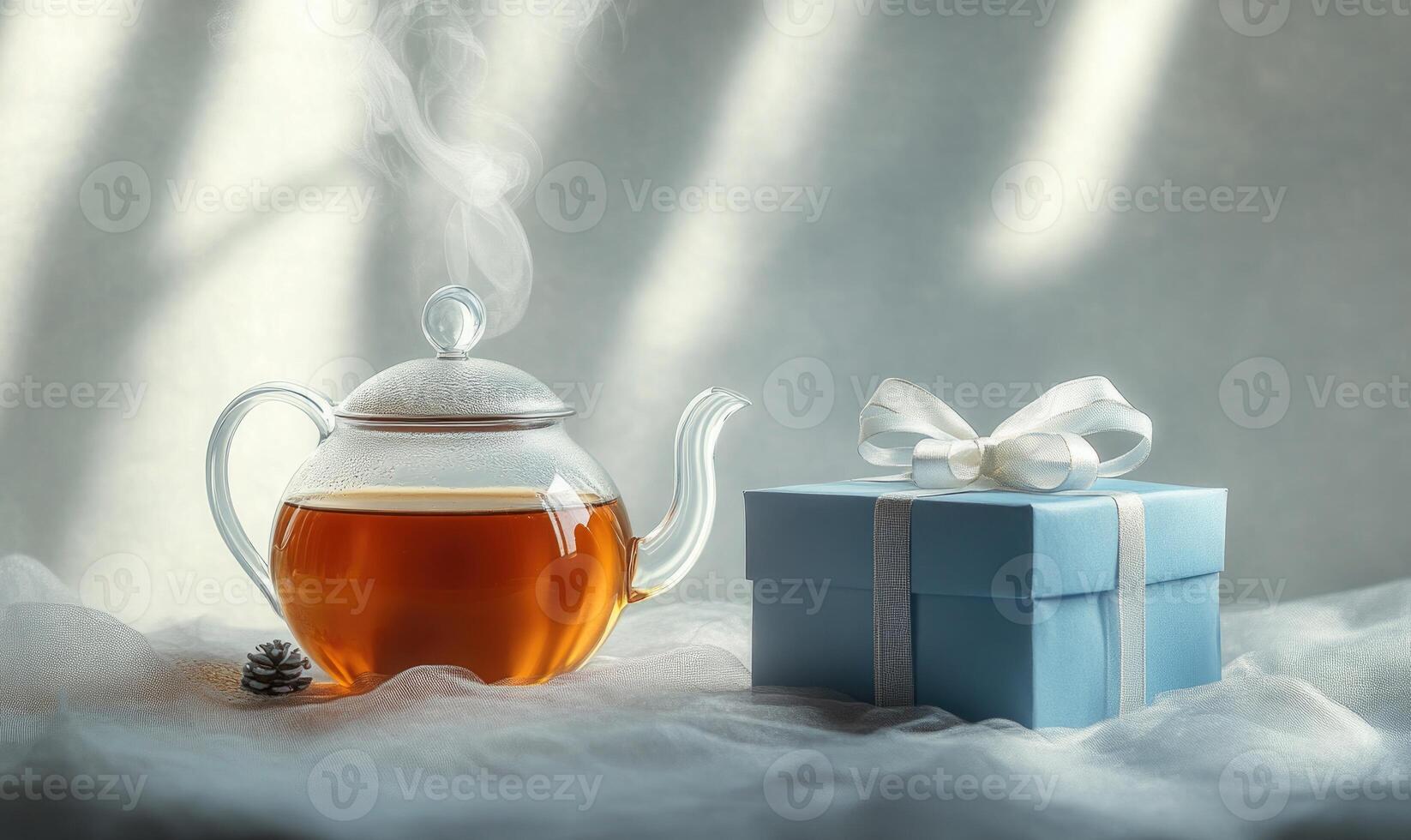 A tea pot with steam coming out of it sits on a table next to a blue box photo
