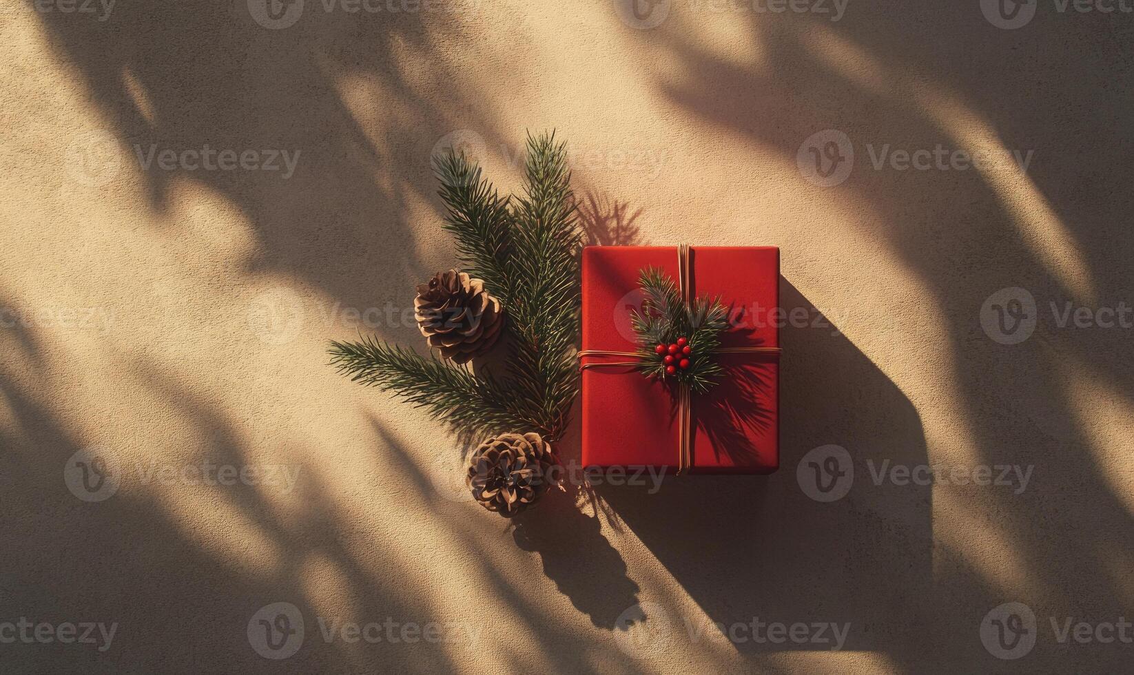 A red box with a green ribbon and pine cones on top of it photo
