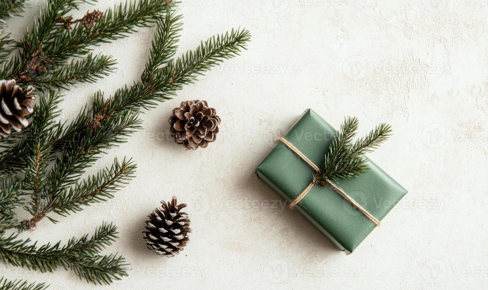 A green box with a ribbon on top sits on a white background with pine cones photo