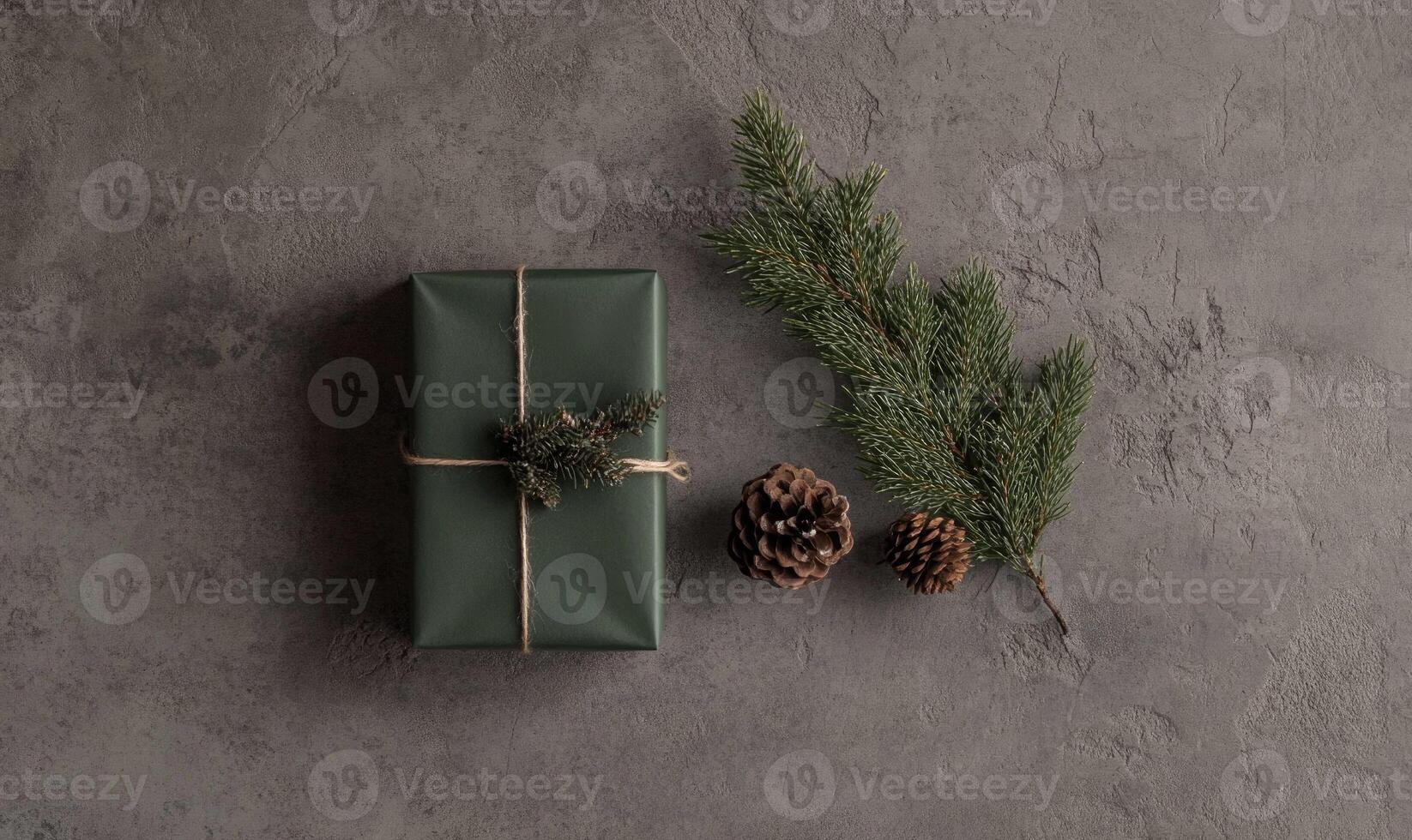 A green box with a ribbon on it sits on a grey surface photo