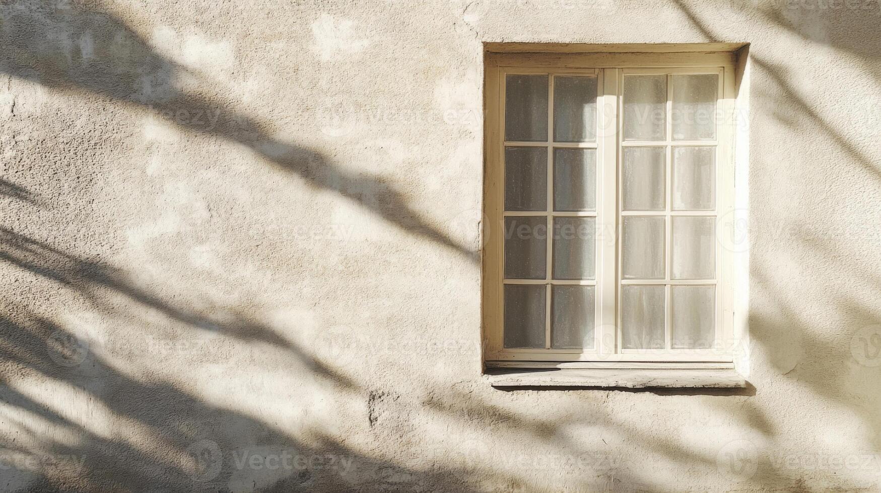A Single Window on a Beige Wall with Shadowy Light photo