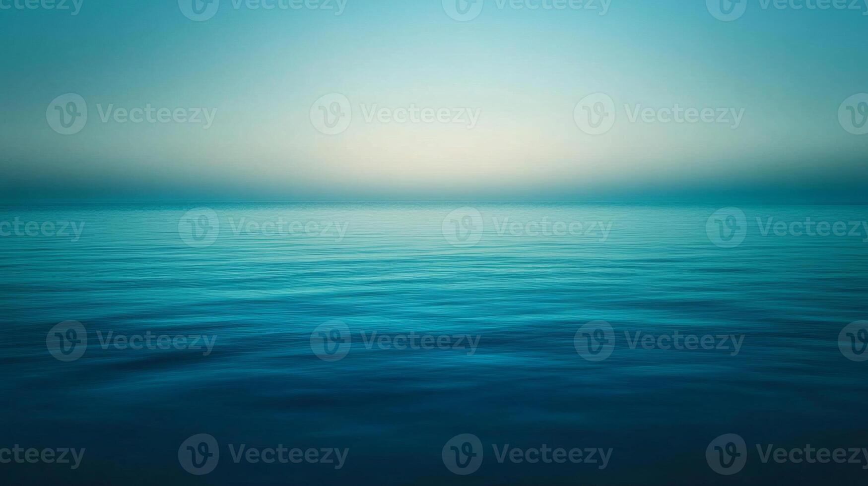 Calm Ocean Surface with a Hazy Sky in the Distance photo