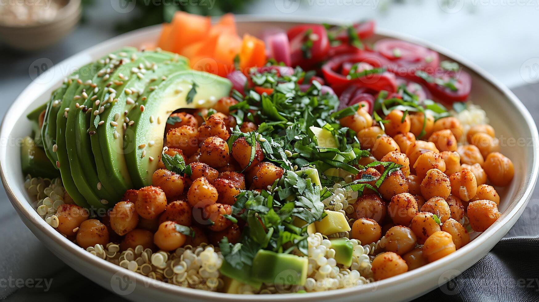 Beautifully plated vegan buddha bowl recipe featuring quinoa avocado slices roasted chickpeas and a colorful array of vegetables arranged in a harmonious pattern on a white plate photo