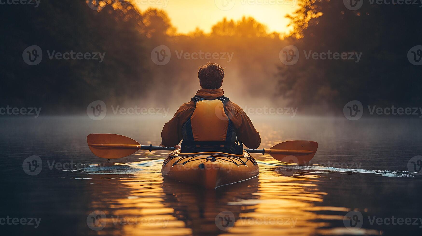 Man rowing a kayak across a calm lake at sunrise water rippling behind him wearing outdoor gear and life vest mist rising from the water photo