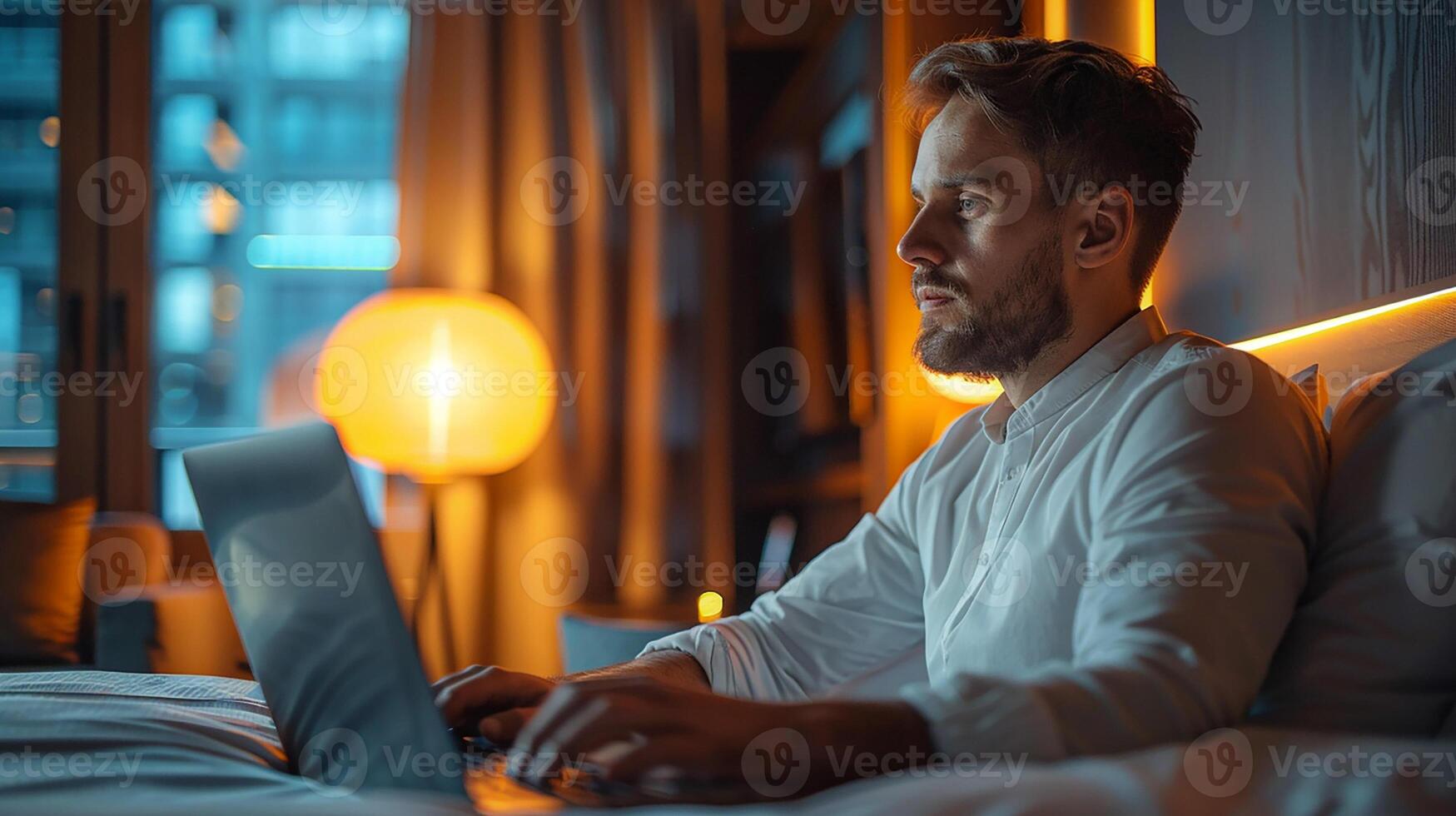 Business traveler working on a laptop in a hotel room, modern workspace setup, photo