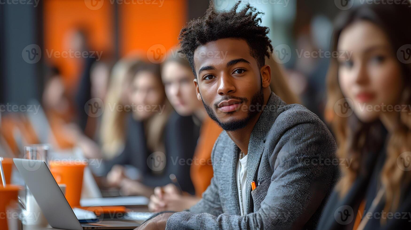 Group of young professionals sitting in a modern office, engaged in a lively discussion around a table, with laptops and notes photo