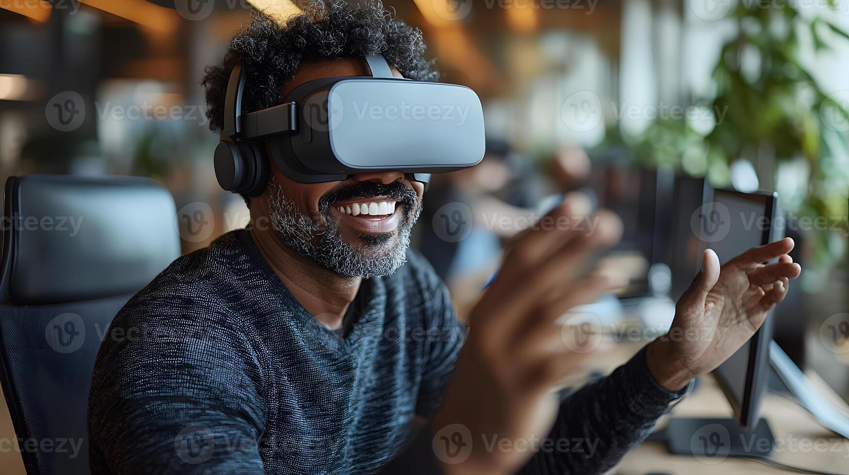 Professional man using virtual reality goggles at his desk, smiling and making expressive gestures, fully engaged in a virtual office environment. photo