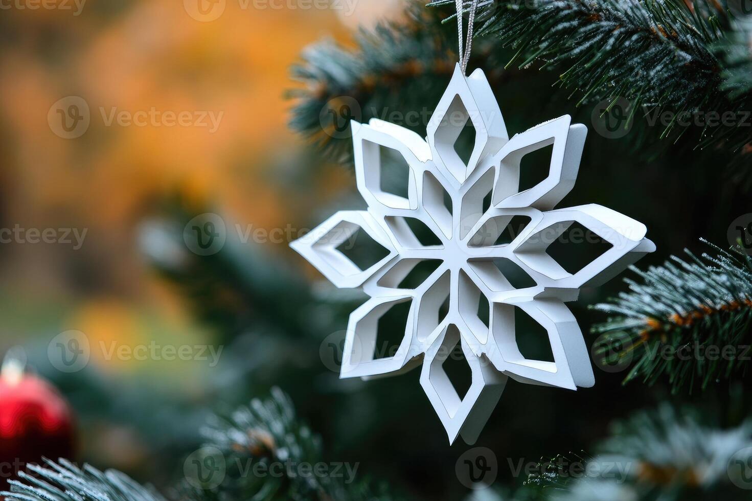 White christmas ornament hanging on a christmas tree with red baubles photo