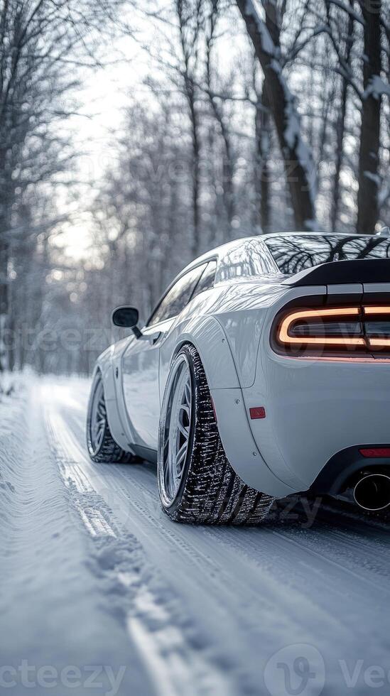 Modern car driving on a snowy road in winter forest photo
