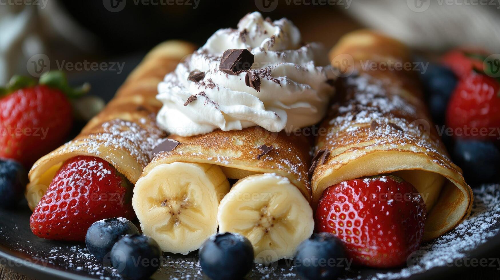 Delicious homemade crepes filled with banana and topped with strawberries, blueberries and whipped cream photo