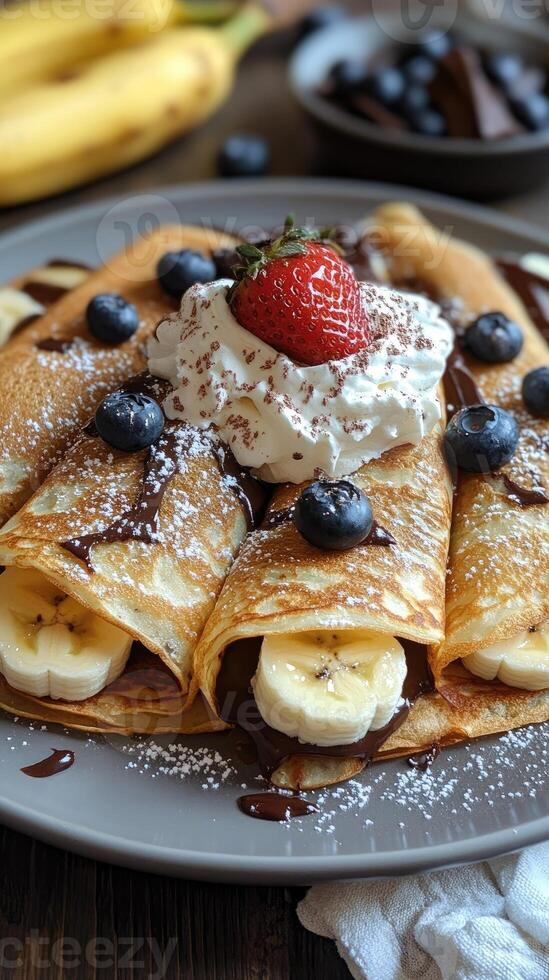 Delicious homemade crepes being topped with whipped cream and chocolate shavings photo