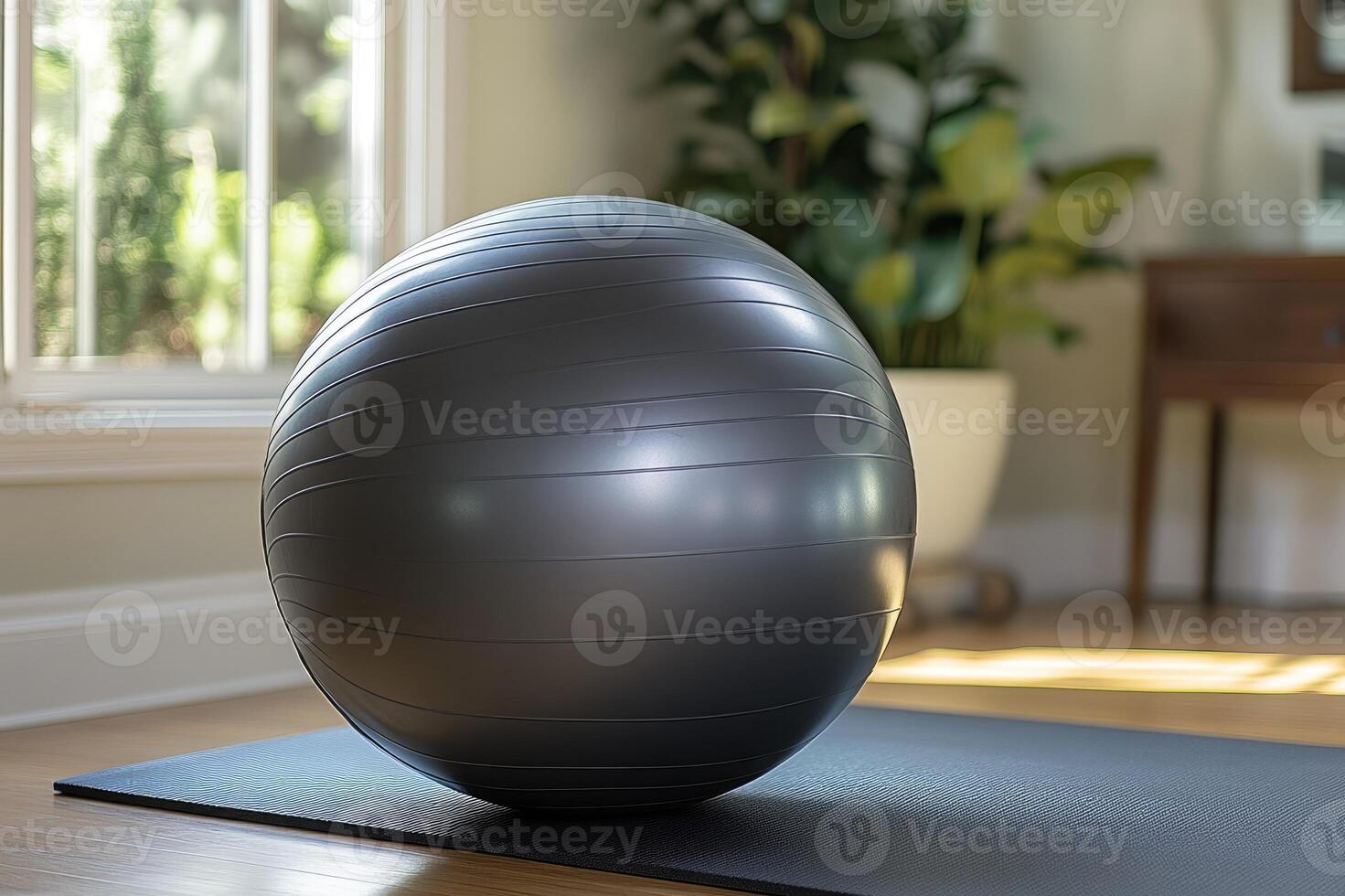 Gray fitness ball laying on yoga mat in living room ready for home workout photo