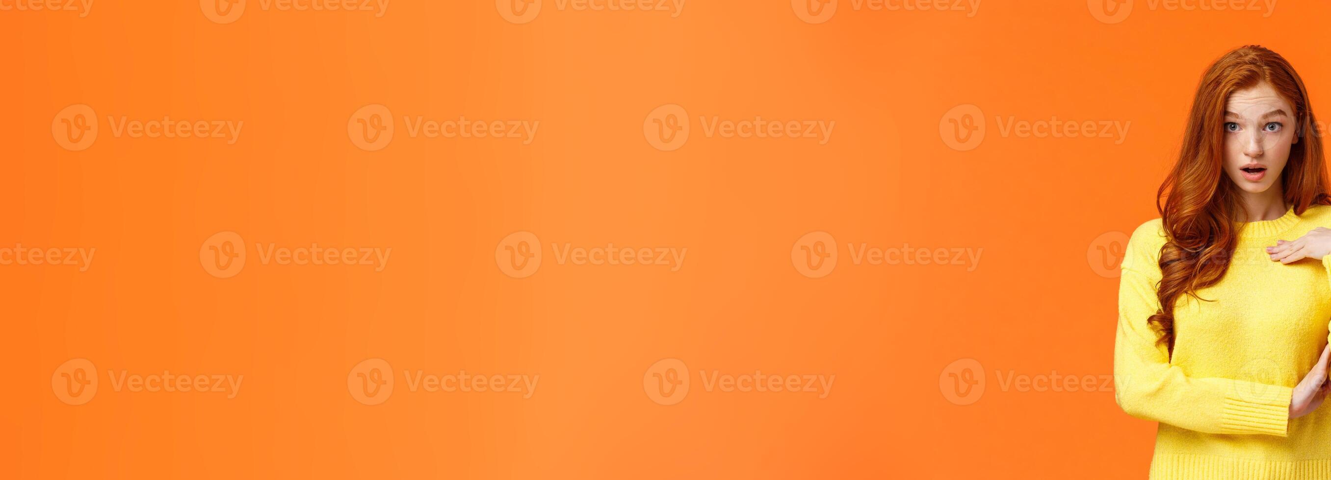 Who me. Frustrated and shocked, confused redhead woman accused, pointing herself and gasping stare astounded, feeling hurt person blame her, receive accusations, orange background photo