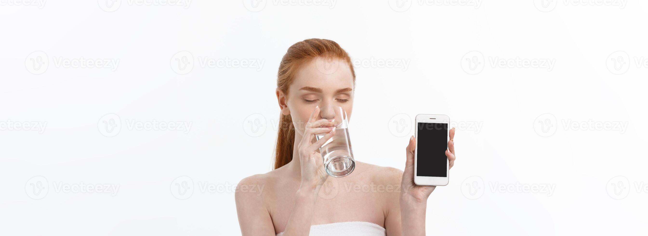 Happy smiling young woman with healthy skin reading and writing in mobile phone sms and drinking clean water. Consulting the diet. Closeup portrait photo