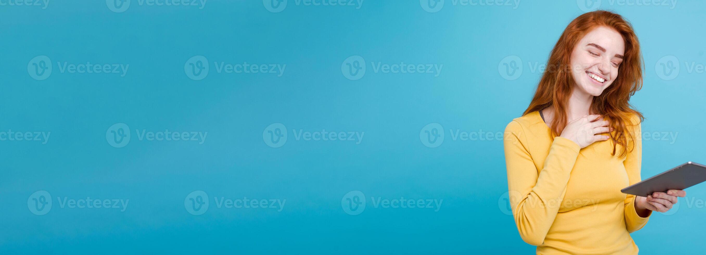 People and Technology Concept - Close up Portrait young beautiful attractive redhair girl happy smiling on digital table with wining something. Blue Pastel Background. Copy space photo