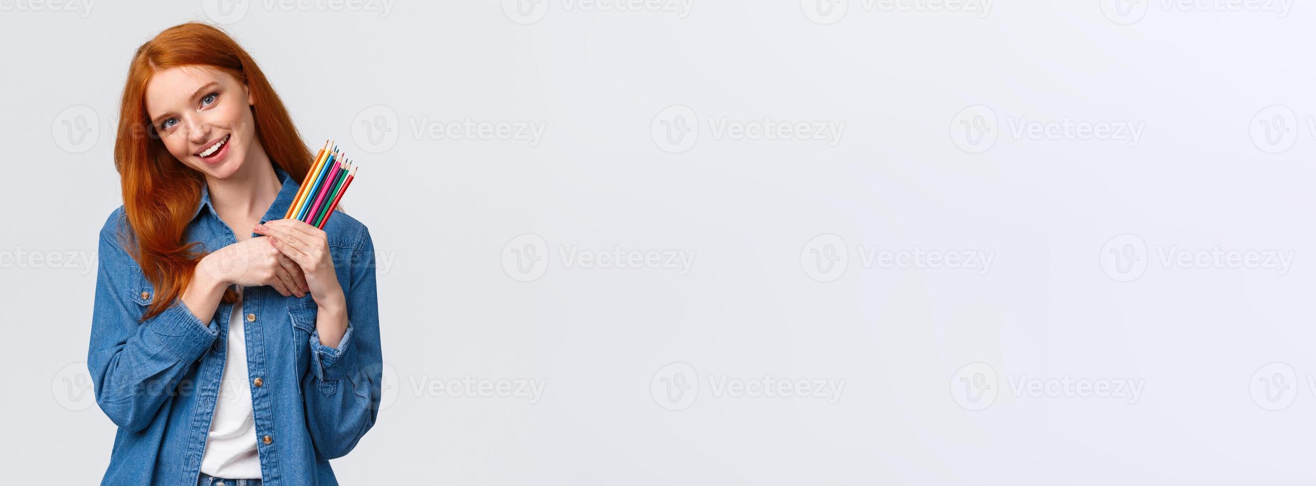 Creativity, imagination and people concept. Cheerful good-looking female college student painting, likes create artworks, holding colored pencils and smiling, tilting head dreamy, white background photo