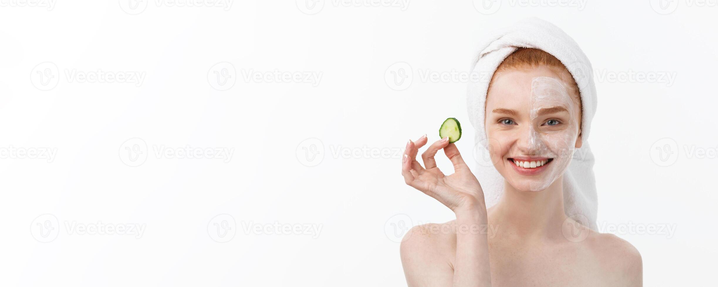 Attractive Young Woman with beautiful clean skin. White mask and cucumbers. Beauty treatments and cosmetology spa therapy. White background photo