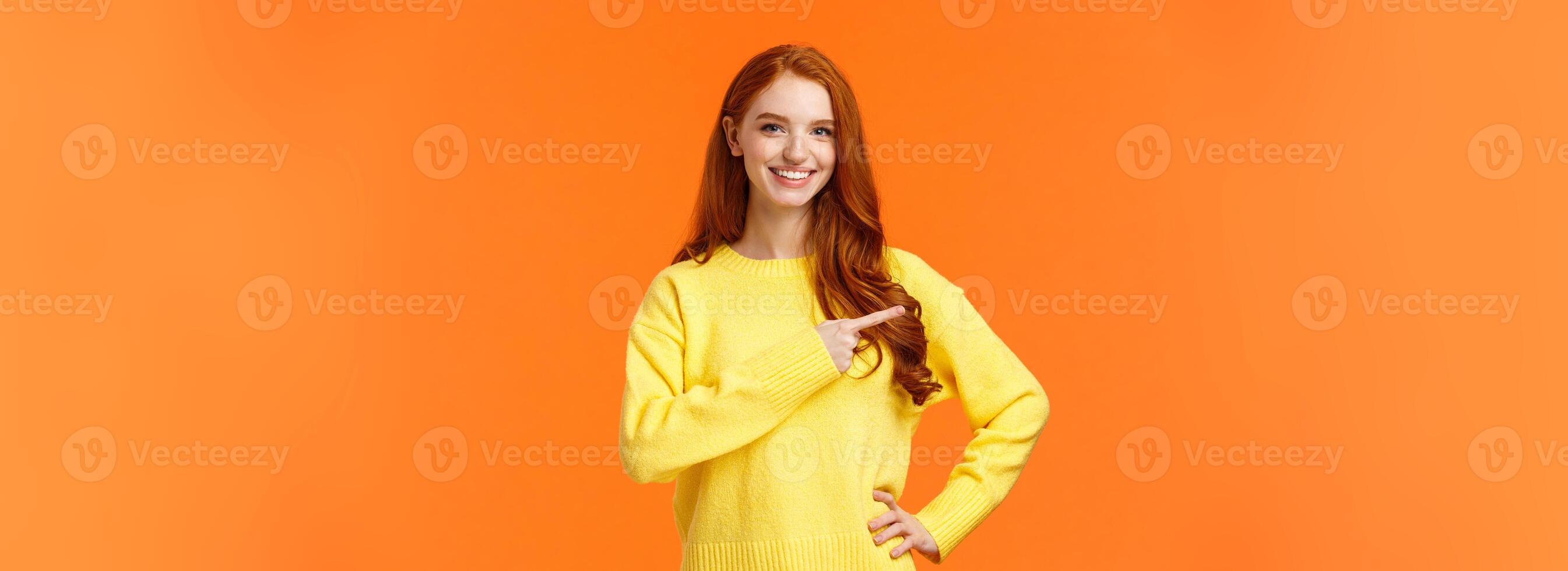Shopping, consumer and holidays concept. Cheerful attractive redhead woman in yellow sweater invite check-out shopping mall sale, pointing left, presenting product, advice click link, smiling photo